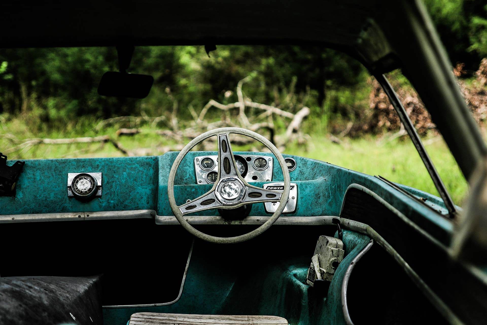 Old boat dashboard with steering wheel.